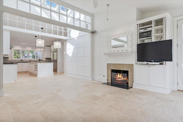 unfurnished living room with a high ceiling and a fireplace with flush hearth