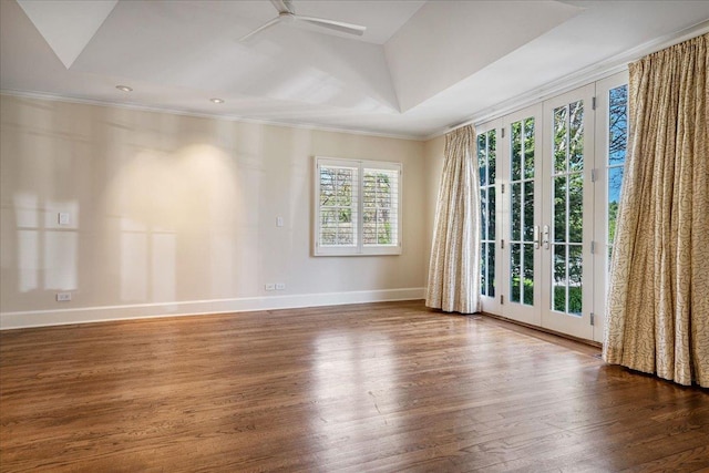 spare room with crown molding, baseboards, ceiling fan, and wood finished floors