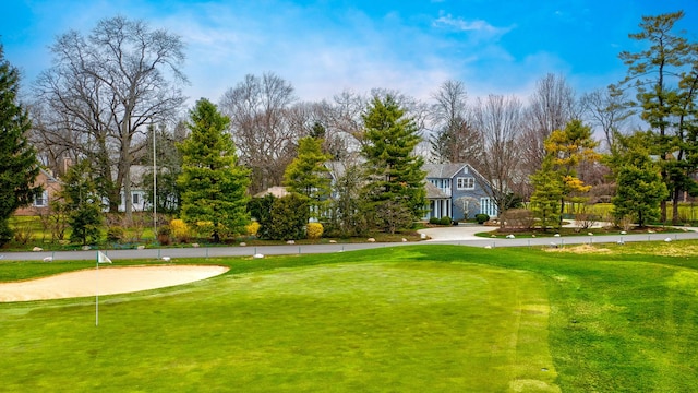 surrounding community featuring view of golf course and a yard
