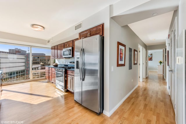 1720 Maple Ave Unit 610, Evanston, IL 60201 - kitchen with stainless steel appliances, light wood finished floors, baseboards, and dark countertops
