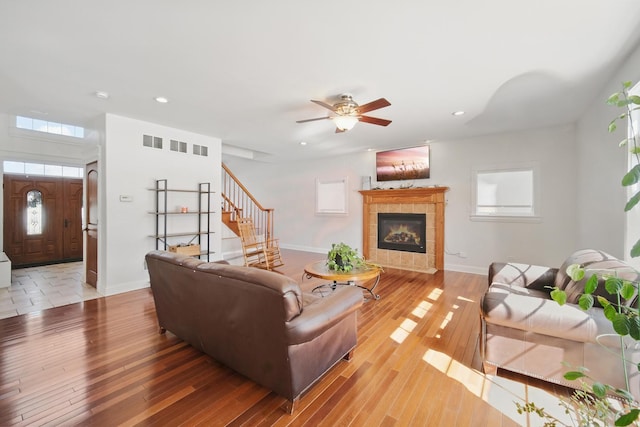 living area featuring baseboards, a tile fireplace, recessed lighting, and light wood finished floors