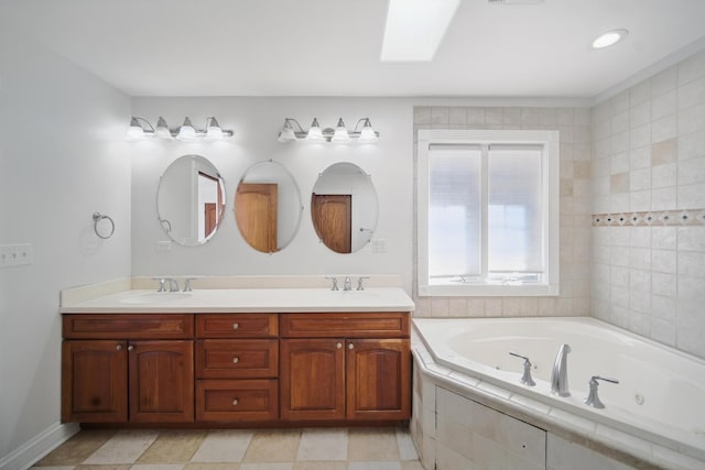 full bath featuring double vanity, a sink, a tub with jets, and a skylight
