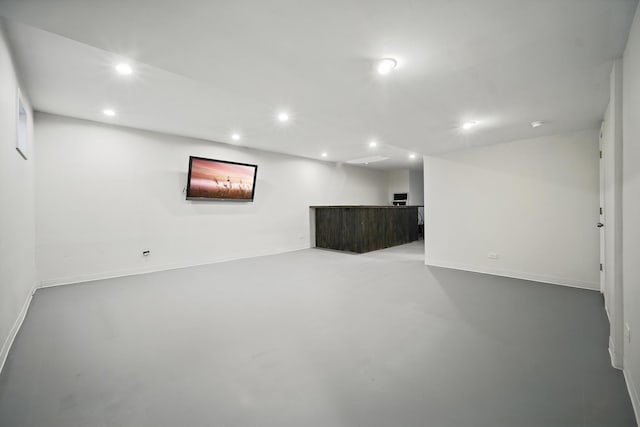 finished basement featuring baseboards, recessed lighting, and indoor bar