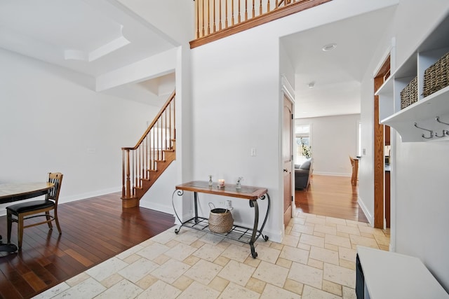 interior space featuring baseboards, light wood-style floors, and stairway
