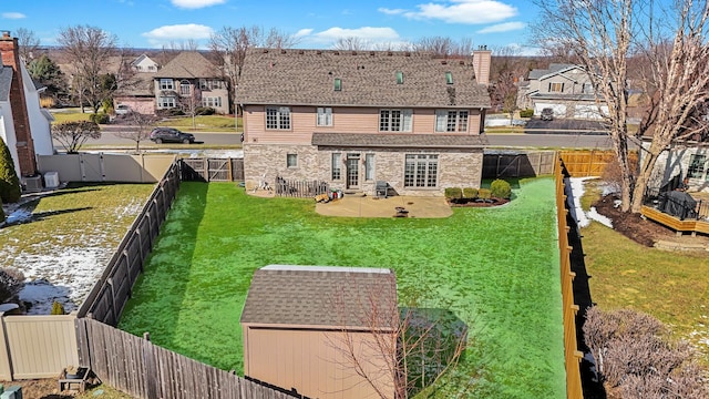 view of yard featuring a fenced backyard, a gate, and an outbuilding