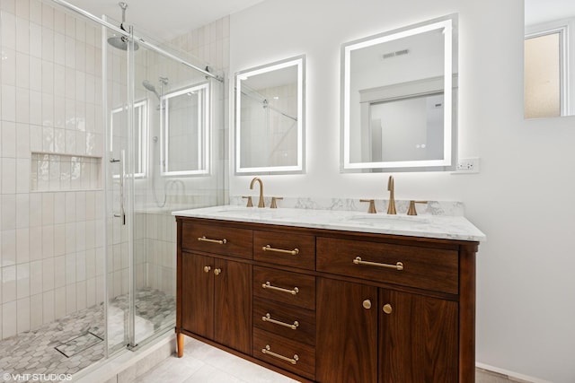 bathroom with a shower stall, visible vents, a sink, and double vanity