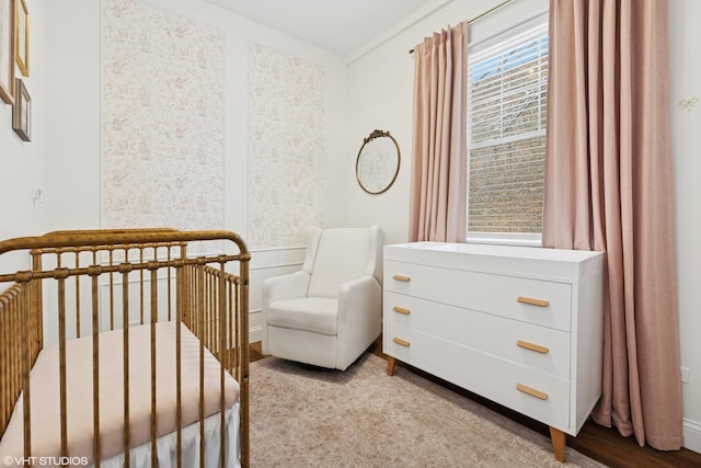 bedroom featuring a crib and wood finished floors