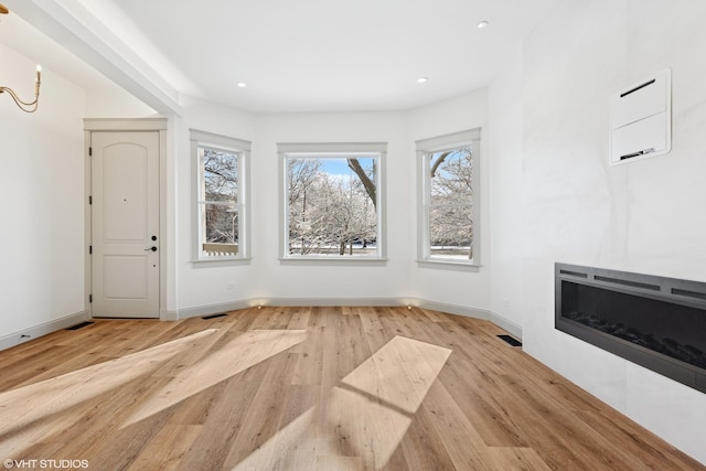 unfurnished living room with a fireplace, visible vents, and wood finished floors