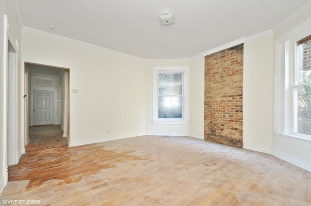 spare room featuring light wood finished floors, baseboards, and ornamental molding
