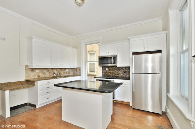 kitchen with white cabinetry, stainless steel appliances, and decorative backsplash