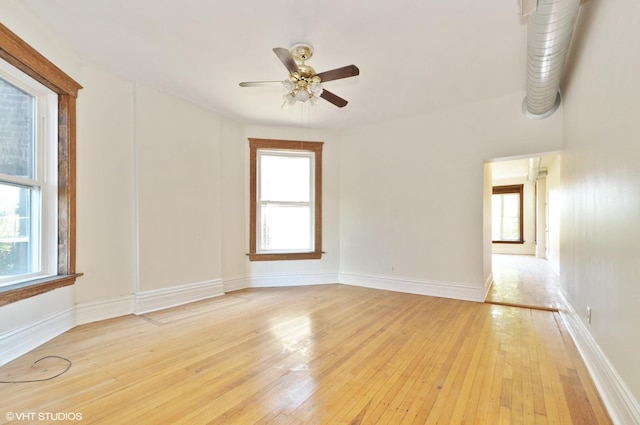 unfurnished room with light wood-type flooring, baseboards, and a ceiling fan