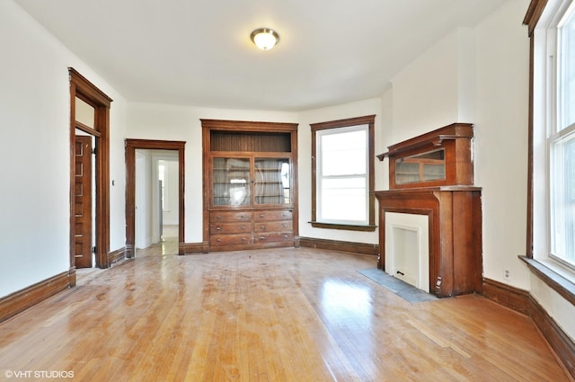 unfurnished living room featuring baseboards and wood finished floors