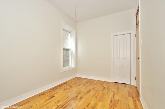 unfurnished room featuring baseboards and light wood-style flooring