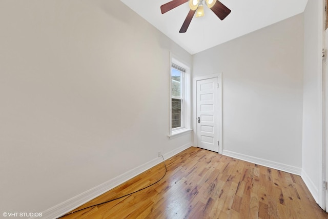 empty room with light wood finished floors, baseboards, and ceiling fan
