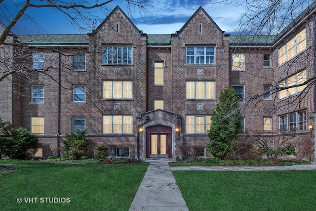 multi unit property featuring brick siding, french doors, and a front yard