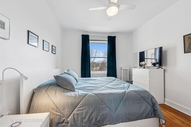 bedroom with ceiling fan, baseboards, and wood finished floors