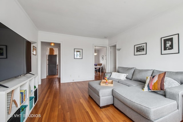living area with crown molding and wood finished floors