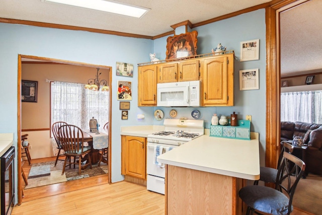 kitchen featuring ornamental molding, wine cooler, white appliances, light wood-type flooring, and light countertops
