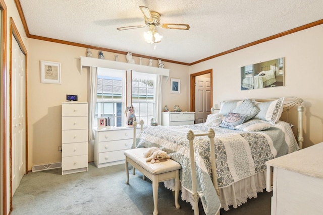 bedroom featuring crown molding, a textured ceiling, carpet flooring, and a ceiling fan