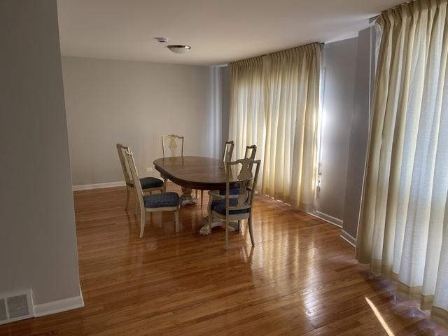 dining room with wood finished floors, baseboards, and visible vents