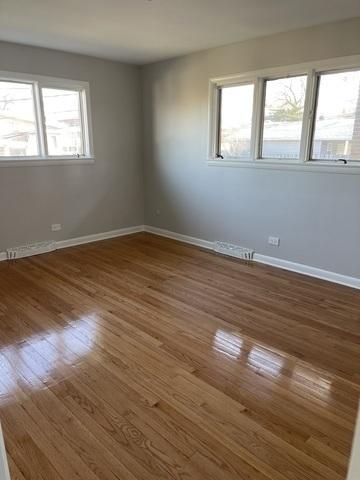 unfurnished room with baseboards and wood finished floors