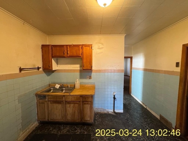 936 N Karlov Ave, Chicago, IL 60651 - kitchen with a wainscoted wall, brown cabinets, tile walls, and a sink