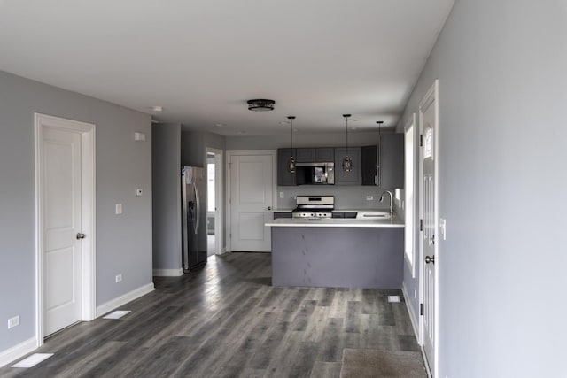 4147 Prairie St, Schiller Park, IL 60176 - kitchen with a peninsula, light countertops, a sink, dark wood finished floors, and appliances with stainless steel finishes