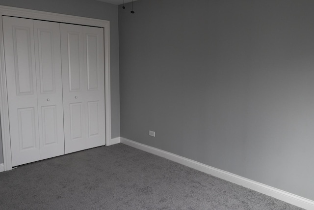 4147 Prairie St, Schiller Park, IL 60176 - unfurnished bedroom featuring baseboards, dark carpet, and a closet