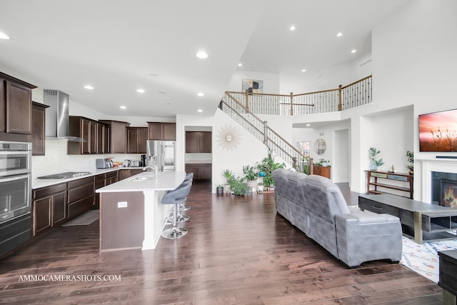 living area featuring recessed lighting, a towering ceiling, and dark wood finished floors