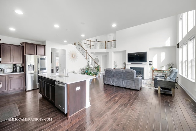 kitchen featuring stainless steel appliances, light countertops, a sink, and dark wood finished floors
