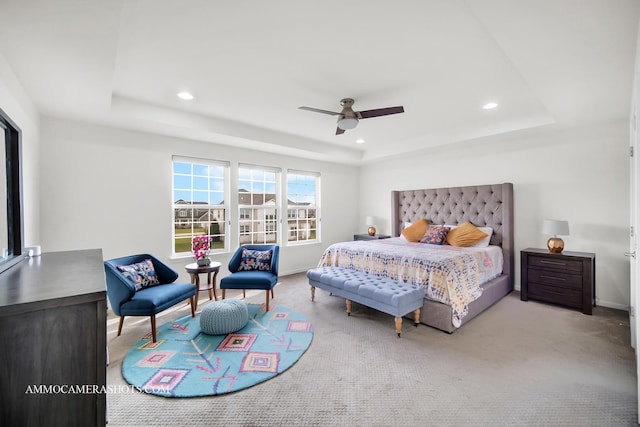 carpeted bedroom featuring recessed lighting, a tray ceiling, baseboards, and a ceiling fan
