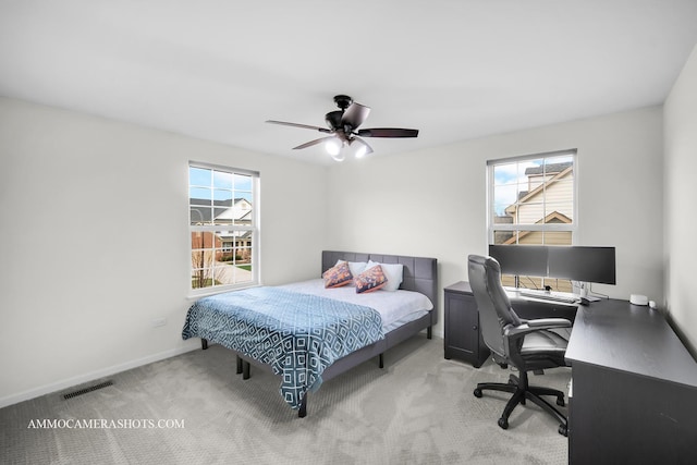 carpeted bedroom with visible vents, multiple windows, baseboards, and ceiling fan