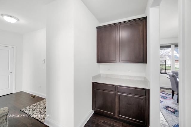 interior space with visible vents, baseboards, and dark wood finished floors