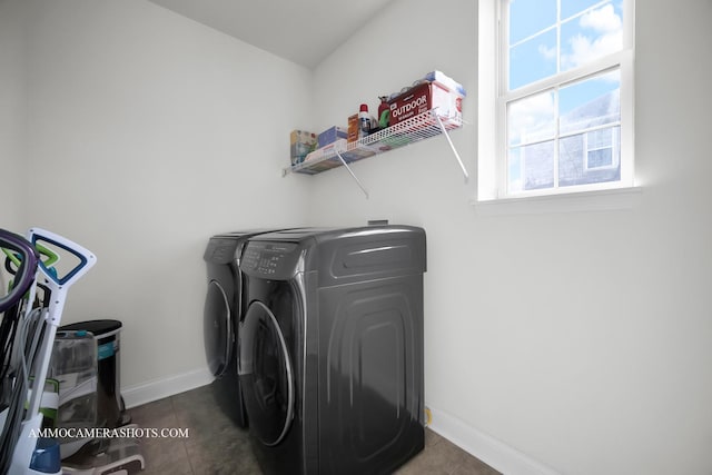 clothes washing area with tile patterned floors, washing machine and clothes dryer, laundry area, and baseboards