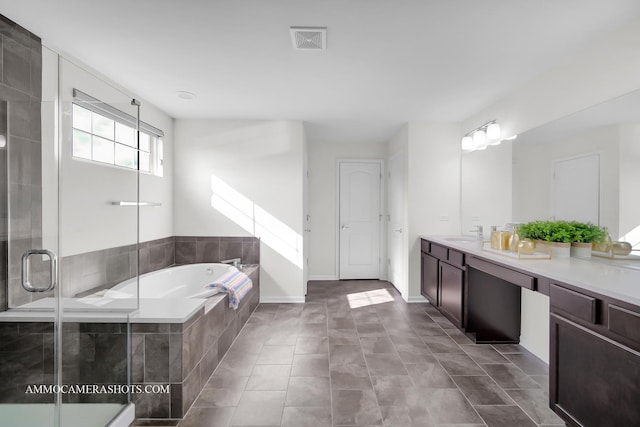 bathroom featuring visible vents, a bath, a sink, double vanity, and a stall shower