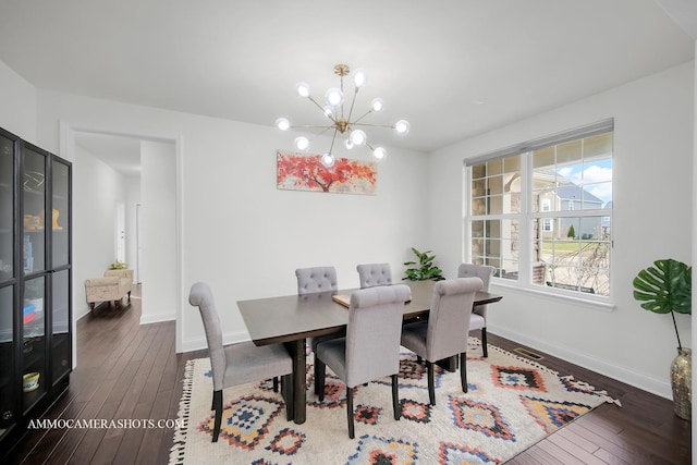 dining room with a chandelier, dark wood-style flooring, and baseboards