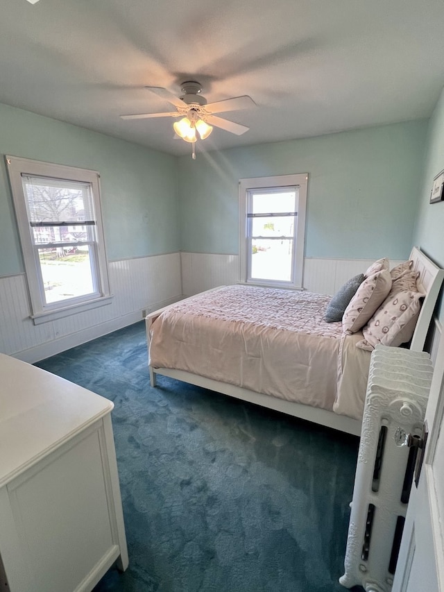 211 W 13th St, Sterling, IL 61081 - carpeted bedroom with a wainscoted wall, multiple windows, and ceiling fan