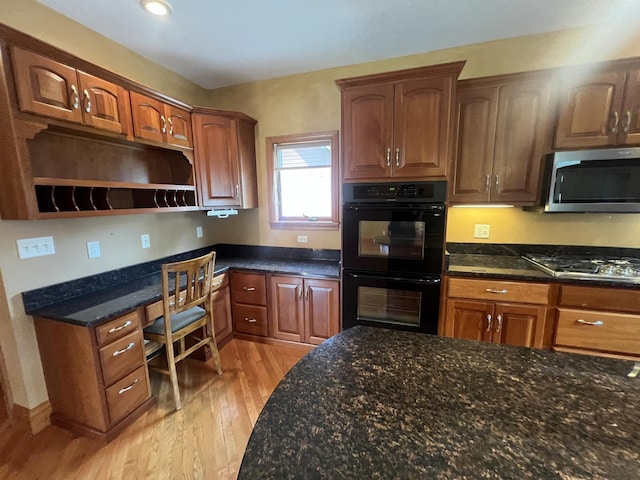 211 W 13th St, Sterling, IL 61081 - kitchen with appliances with stainless steel finishes, light wood-style flooring, open shelves, dark stone countertops, and brown cabinets