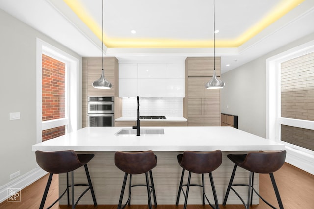 kitchen with modern cabinets, stainless steel double oven, white cabinets, a sink, and backsplash