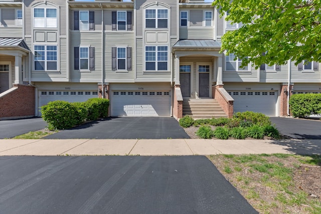 3576 Gabrielle Ln, Aurora, IL 60504 - townhome / multi-family property featuring a garage, asphalt driveway, brick siding, a standing seam roof, and metal roof
