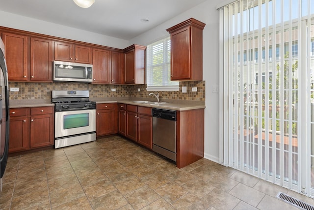 3576 Gabrielle Ln, Aurora, IL 60504 - kitchen with stainless steel appliances, a sink, tasteful backsplash, light countertops, and brown cabinets