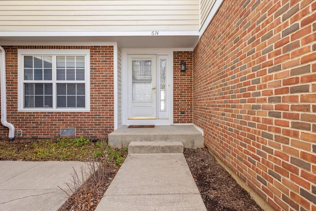 property entrance with brick siding and crawl space