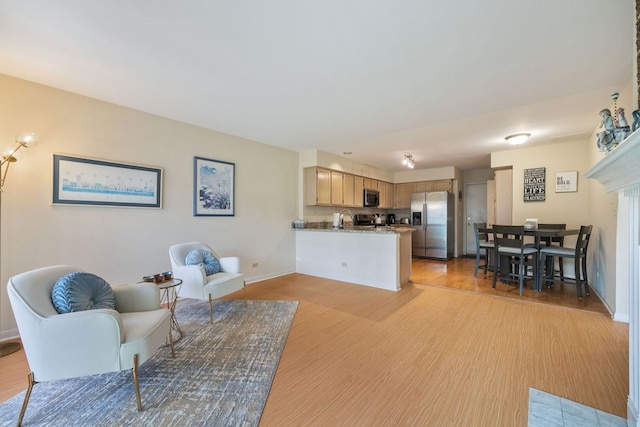 living area with baseboards and light wood finished floors
