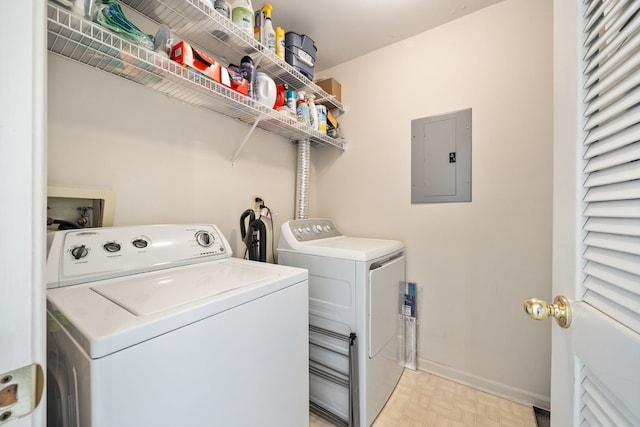 washroom featuring electric panel, washing machine and dryer, light floors, laundry area, and baseboards