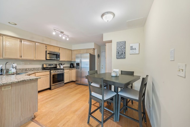kitchen featuring a sink, light brown cabinets, appliances with stainless steel finishes, and light wood finished floors