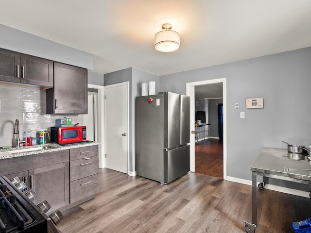 339 Clyde Ave, Calumet City, IL 60409 - kitchen with light countertops, dark brown cabinetry, a sink, freestanding refrigerator, and wood finished floors