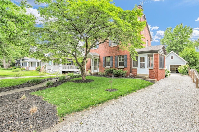 708 W Church St, Champaign, IL 61820 - view of front of house with brick siding, a front yard, an outbuilding, and driveway