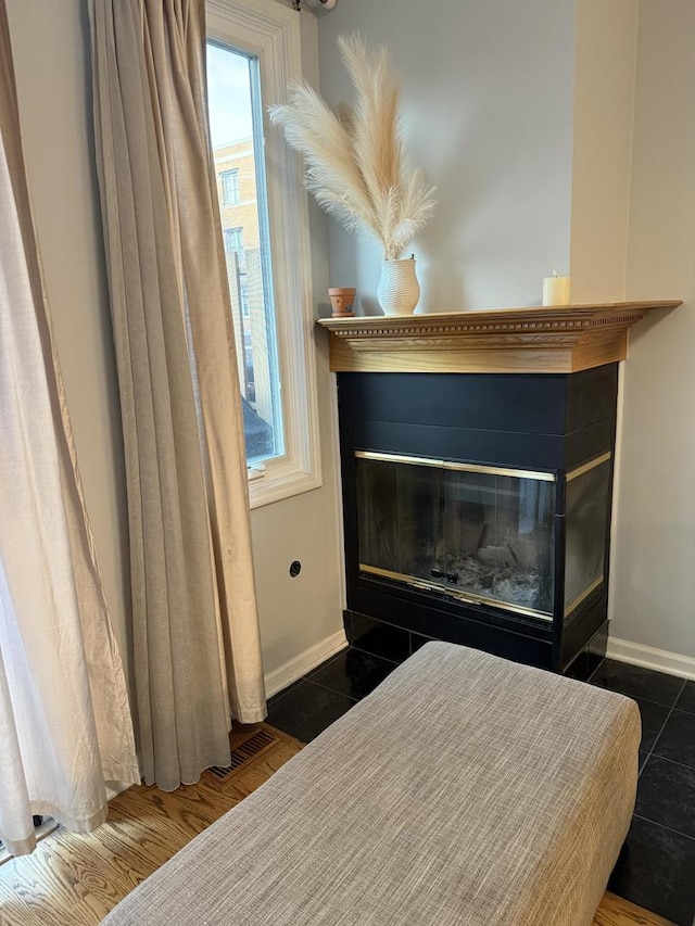 room details featuring a fireplace with flush hearth, visible vents, and baseboards