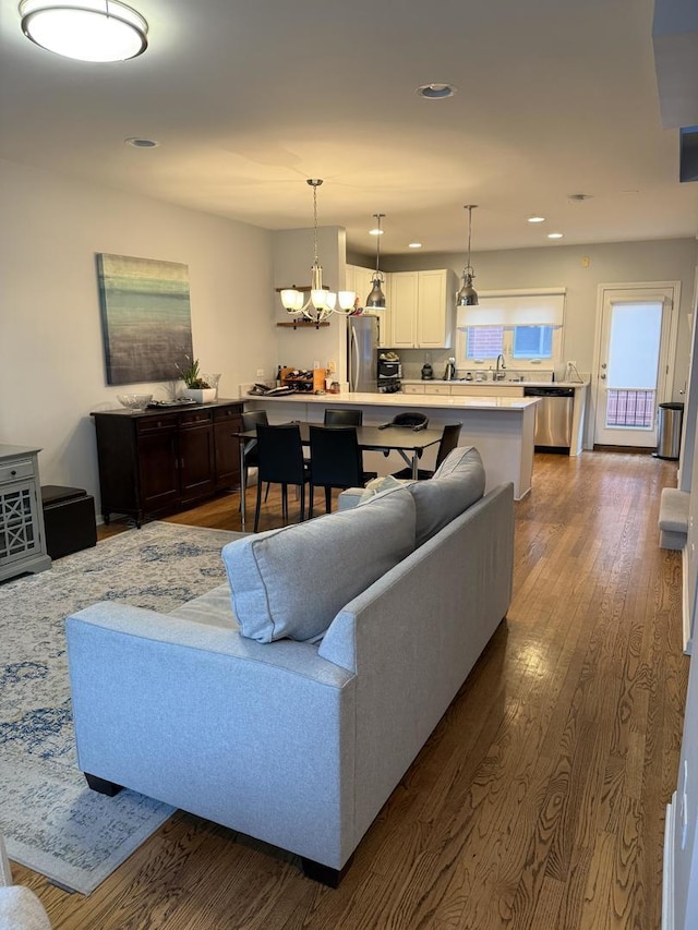 living room featuring dark wood-style flooring, recessed lighting, and a chandelier
