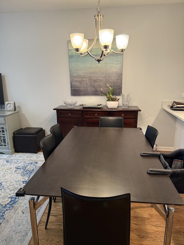 dining space with a notable chandelier and wood finished floors